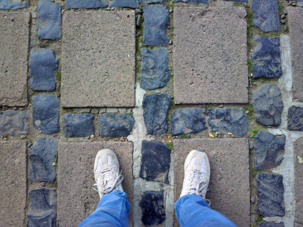 istock Feet on the tile.  Man's feet on the stones. 1143089072