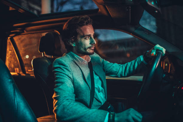 istock Businessman Driving A Car In Night 1143089742