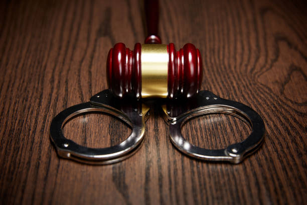istock HANDCUFFS, GAVEL ON WOOD 1143089762