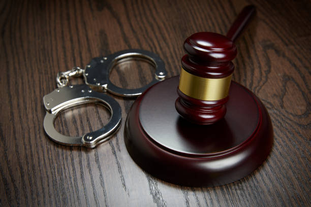 istock HANDCUFFS, GAVEL ON WOOD 1143089986