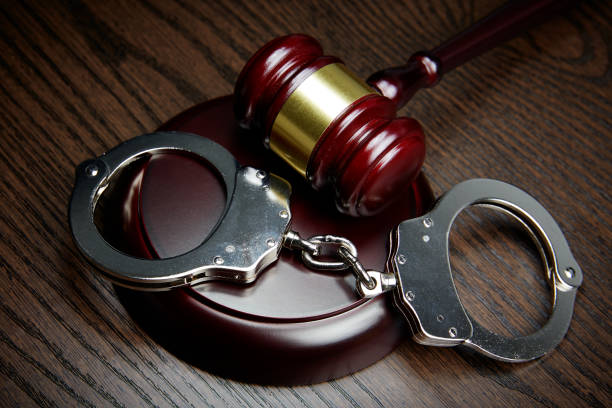 istock HANDCUFFS, GAVEL ON WOOD 1143090342