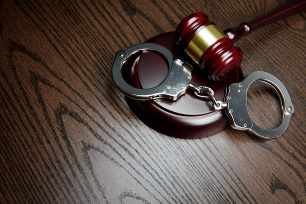 istock HANDCUFFS, GAVEL ON WOOD 1143090357