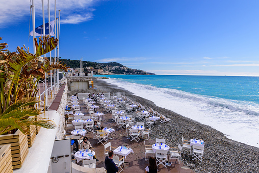 Nice city, France - March 7, 2018: restaurant on the Mediterranean coast. Tables and chairs on the beach.
