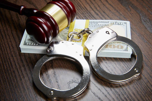 istock MONEY, GAVEL AND HANDCUFFS ON WOOD 1143091237