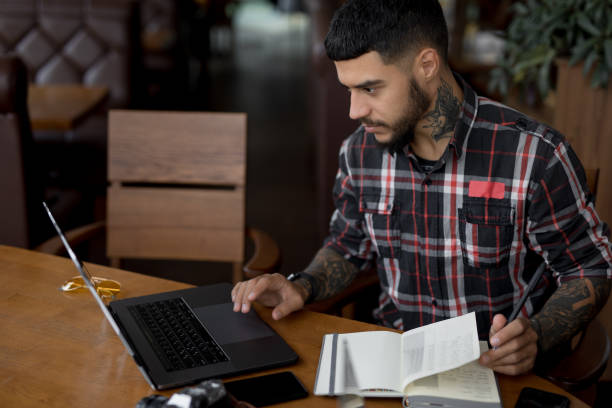 istock Stylish handsome man freelancer working by laptop computer in cafe 1143091593