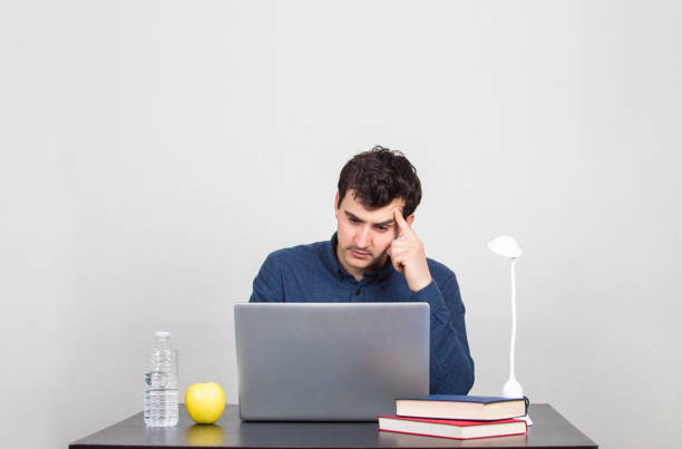 istock male student thinking intensively looking at a lapto 1143092866