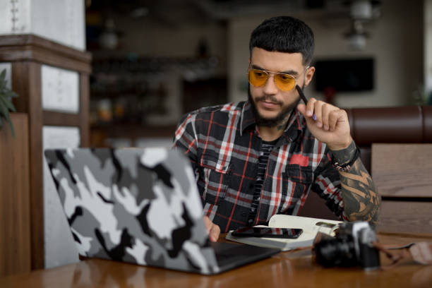 istock Stylish handsome man freelancer working by laptop computer in cafe 1143094418