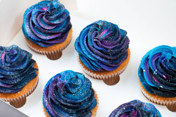 istock Box with vanilla cupcakes with galaxy dark whipped cream 1143098262