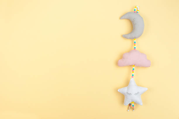 Baby toy on yellow background with blank space for text; top view, flat lay