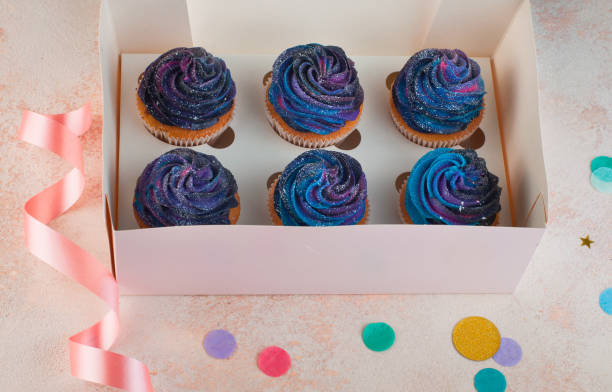 istock Box with vanilla cupcakes with galaxy dark whipped cream 1143098448