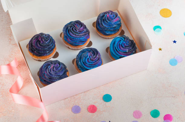 istock Box with vanilla cupcakes with galaxy dark whipped cream 1143098478