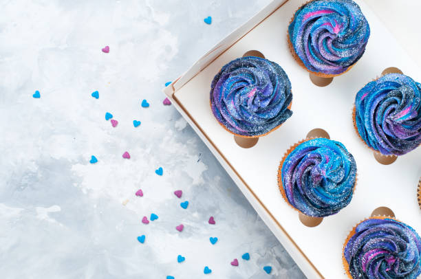 istock Box with vanilla cupcakes with galaxy dark whipped cream 1143099076