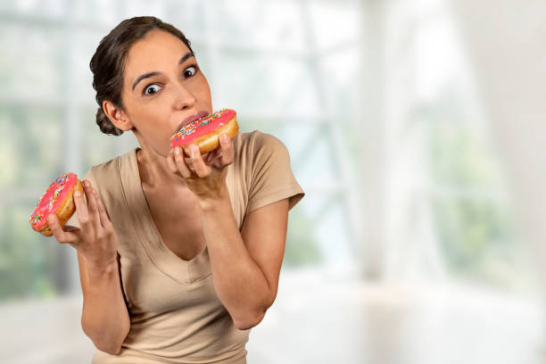 istock Woman eating a huge donut 1143099729