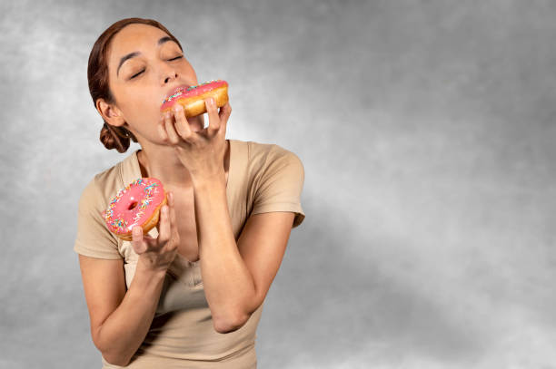 istock Woman eating a huge donut 1143100741