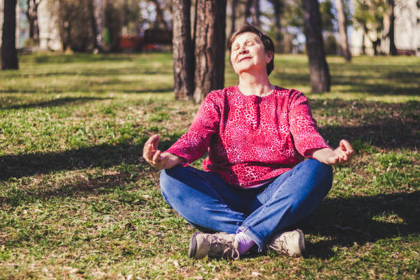 istock Senior woman practicing yoga in the park 1143101663