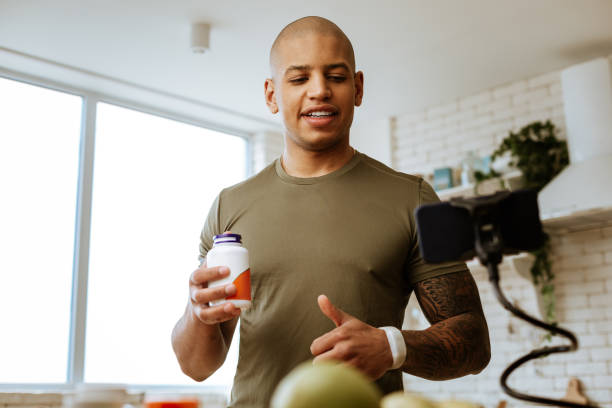 istock Bodybuilder with tattoo on hand making video about supplements 1143103423