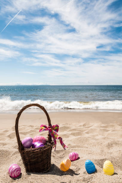 Easter bunny with color eggs on the ocean beach stock photo