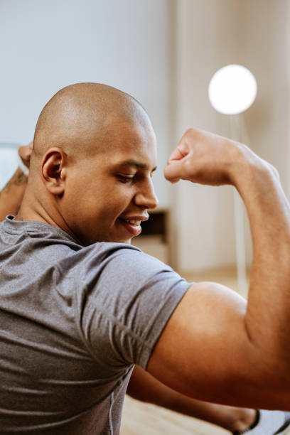 istock Young strong man going to gym looking at his big biceps 1143103515
