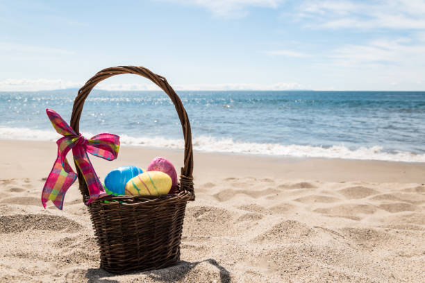 Easter bunny with color eggs on the ocean beach stock photo