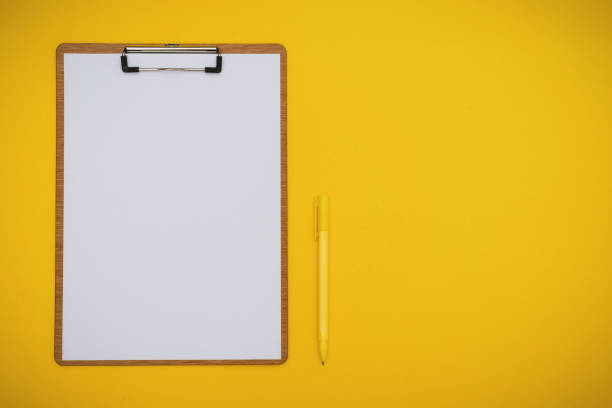 istock Paper on Clipboard and Pen on Yellow Background 1143106619