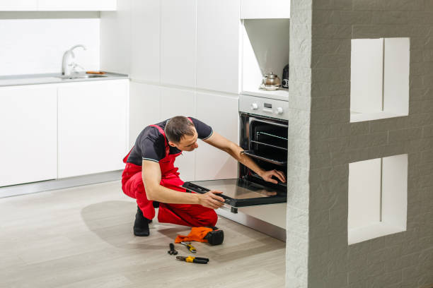 oung man repairing oven in kitchen