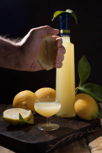 리 몬 첼로 병 및 술과 작은 샷. 감귤 류에서 이탈리아의 전통�적인 알콜 음료. 신선한 과일과 음료. 텍스트를 위한 여유 공간. 프레임에 손 - neapolitan specialty 뉴스 사진 이미지