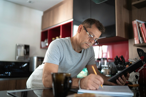 Man taking notes while doing home office