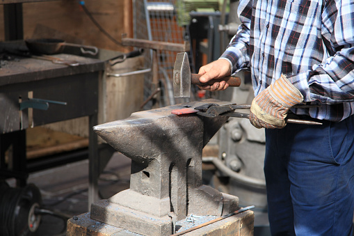 Blacksmith working on his anvil with his hammer