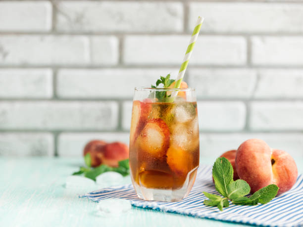 il bicchiere di tè di ghiaccio alla pesca su tavolo di legno. - peach nectarine wet drop foto e immagini stock