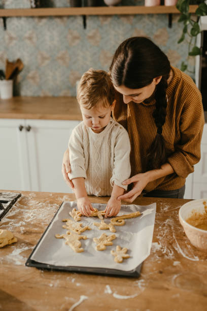 mère et fils faisant des biscuits - home baking photos et images de collection