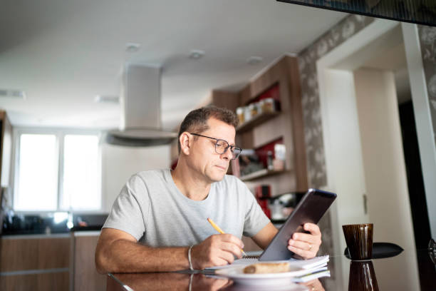 człowiek robi biuro domowe - wireless technology working at home one person reading zdjęcia i obrazy z banku zdjęć