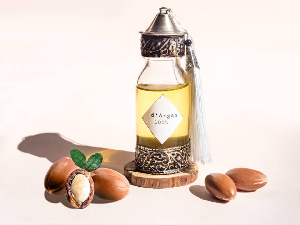 貴重なモロッコのアルガンオイルとナッツが ander た伝統的なモロッコ風の装飾ボトル、太陽の自然光 - アルガンオイル ストックフォトと画像