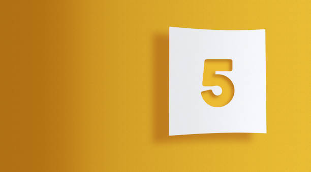 Number 5 cut out on white square paper on yellow background with large copy space