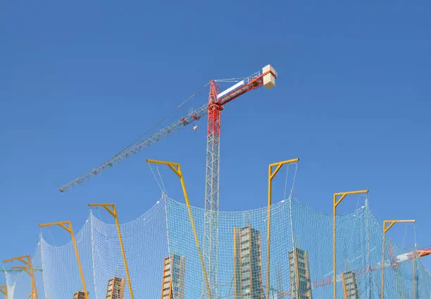 Industrial Crane, safety net, cement formworks mold clear blue sky sunny day