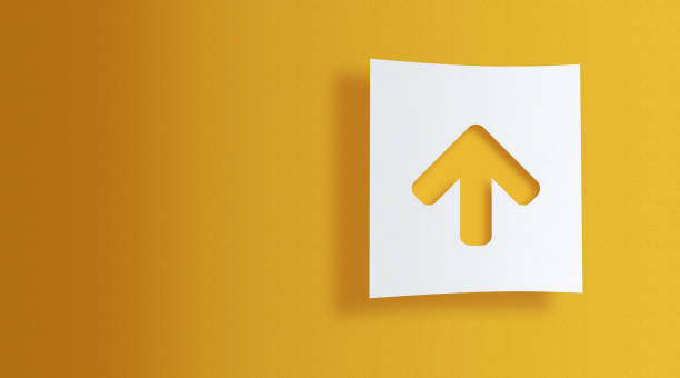up arrow cut out on white square paper on yellow background with large copy space