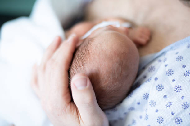 père prenant soin de son bébé prématuré faisant la peau à la peau à l’hôpital - service de maternité photos et images de collection