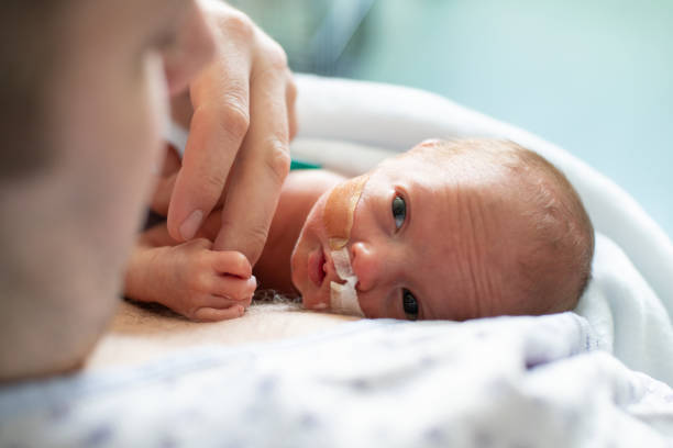 Father taking care of his premature baby doing skin to skin at hospital stock photo