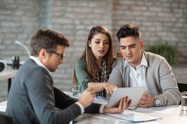 istock Young couple and financial advisor going through investment plans on digital tablet. 1143135513