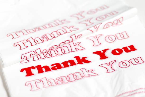 Stack of new plastic shopping bags with red Thank You text.