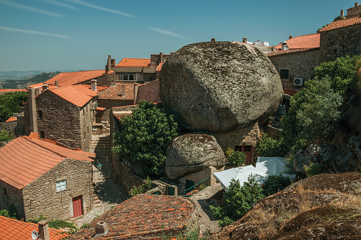 Monsanto, Portugal - July 13, 2018. Rooftops of old stone houses with rocks and alley among them in a sunny day at Monsanto. Considered one of the cutest and most peculiar historic village of Portugal