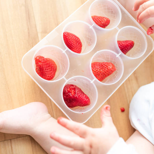 istock Little baby boy playing with strawberries 1143140676