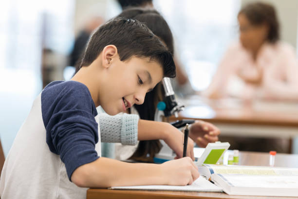 istock Male middle school student works studies in library 1143140903