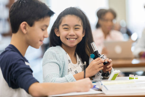 istock Happy schoolgirl working on science homework 1143140910