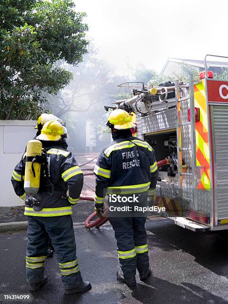 Firefighters At A House Fire Stock Photo - Download Image Now - Breathing Device, City Life, Clothing