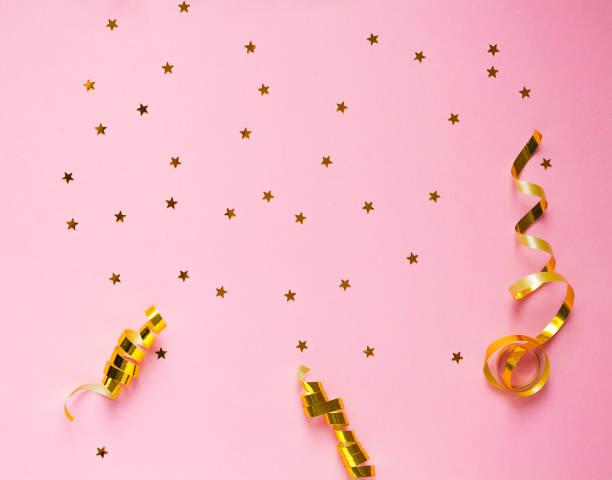 istock Golden decorations and sparkles on pink background 1143145739