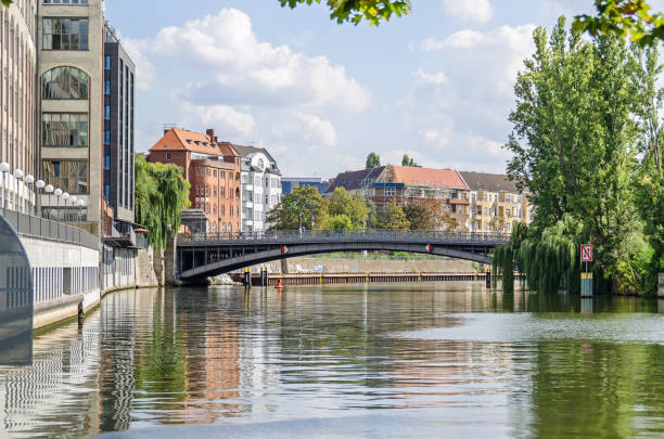 Banks of the River Spree with the bridge Gotzkowskybruecke in Berlin, Germany Berlin, Germany - September 4, 2018: Embankment of the River Spree Wikingerufer with the bridge Gotzkowskybruecke which is under the preservation order, the buildings of Adrema hotel and a parish hall of the Protestant Church of the Redeemer moabit stock pictures, royalty-free photos & images