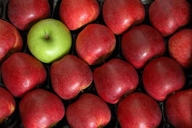 Photo of One Green Apple among the Reds