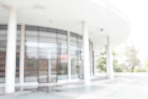 istock Office or university building blur background exterior view with blurry empty lobby space, entrance hall glass wall window and light bokeh 1143163356