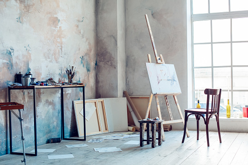 Creative artist workplace room nobody hobby easel and chair near the window