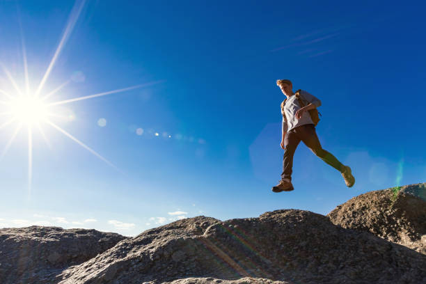 istock Man jumping over gap on mountain hike 1143164744